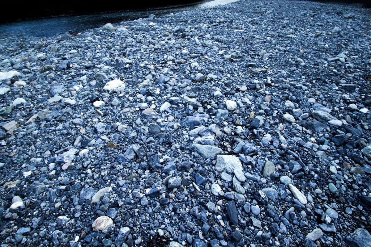 Sorted cobble and gravel along a river margin. Decomposed granite is what the 2023 storm moved into Cheesman by the cubic yard, and what the 2024 flushing releases pushed back out.