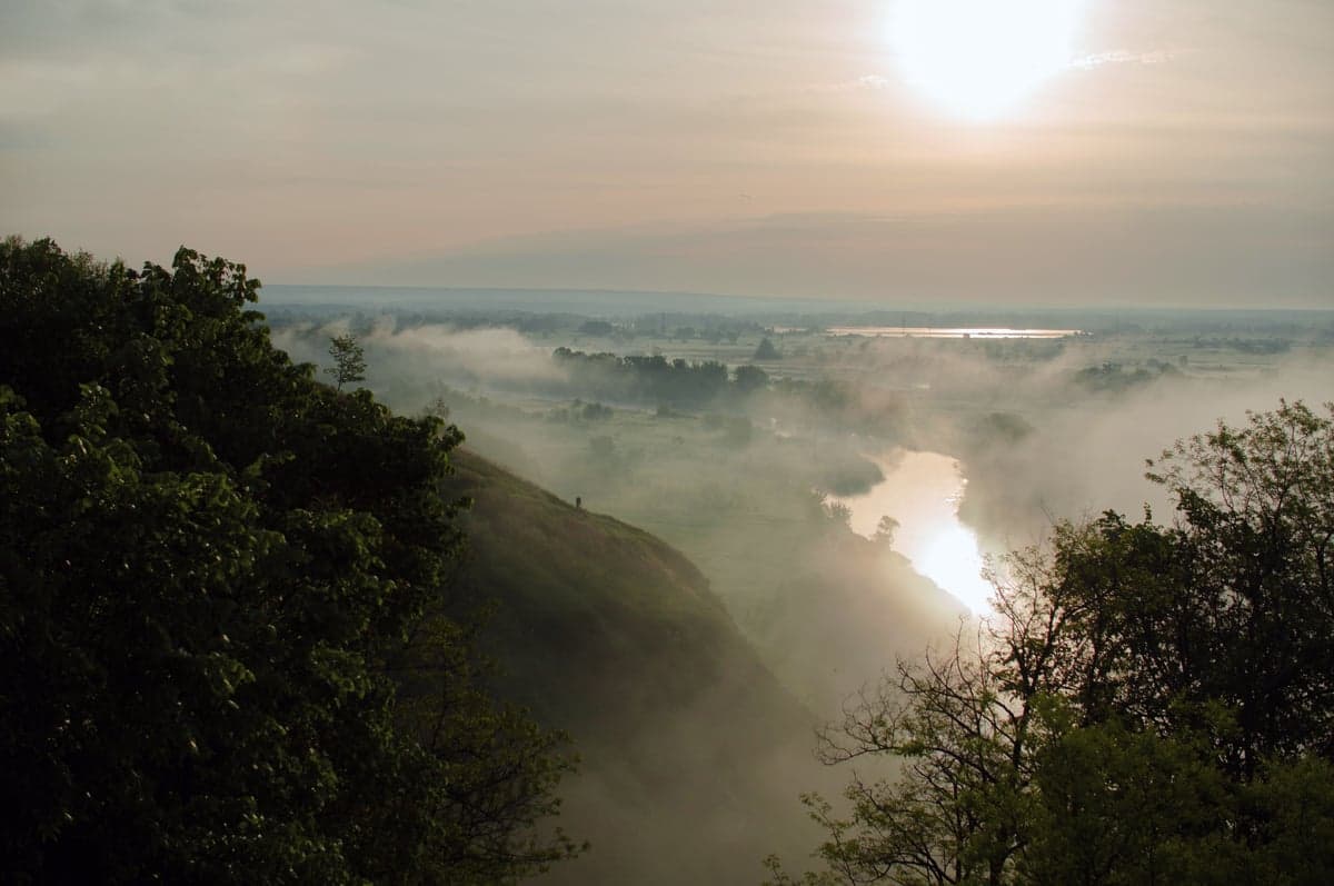 Morning fog lifting from a river valley at sunrise. On the Deschutes, early mornings are the most productive fishing window during summer heat.