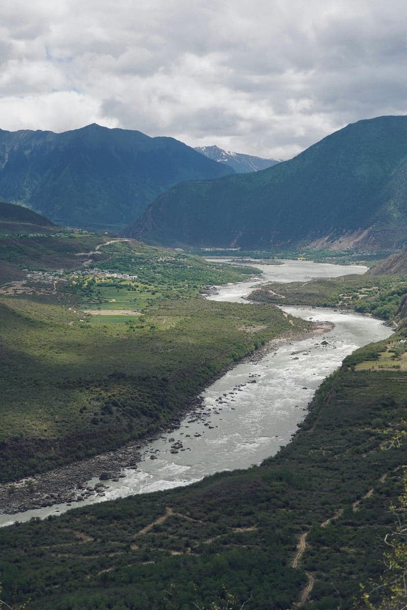 A river meanders through a mountain valley, typical of the meadow water on the Lamar, Slough Creek, and upper Yellowstone
