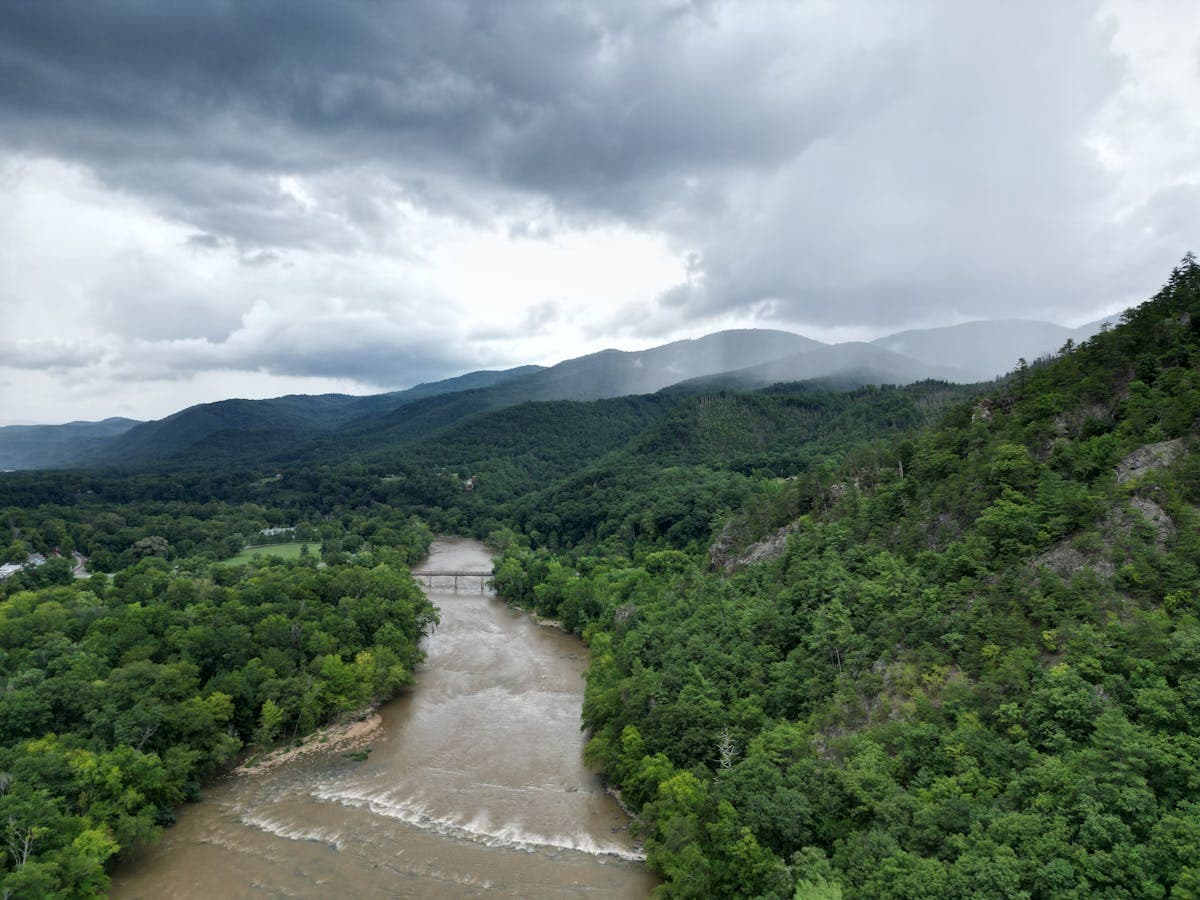 Aerial view of lush green landscape and the French Broad River in the mountains near Hot Springs, NC