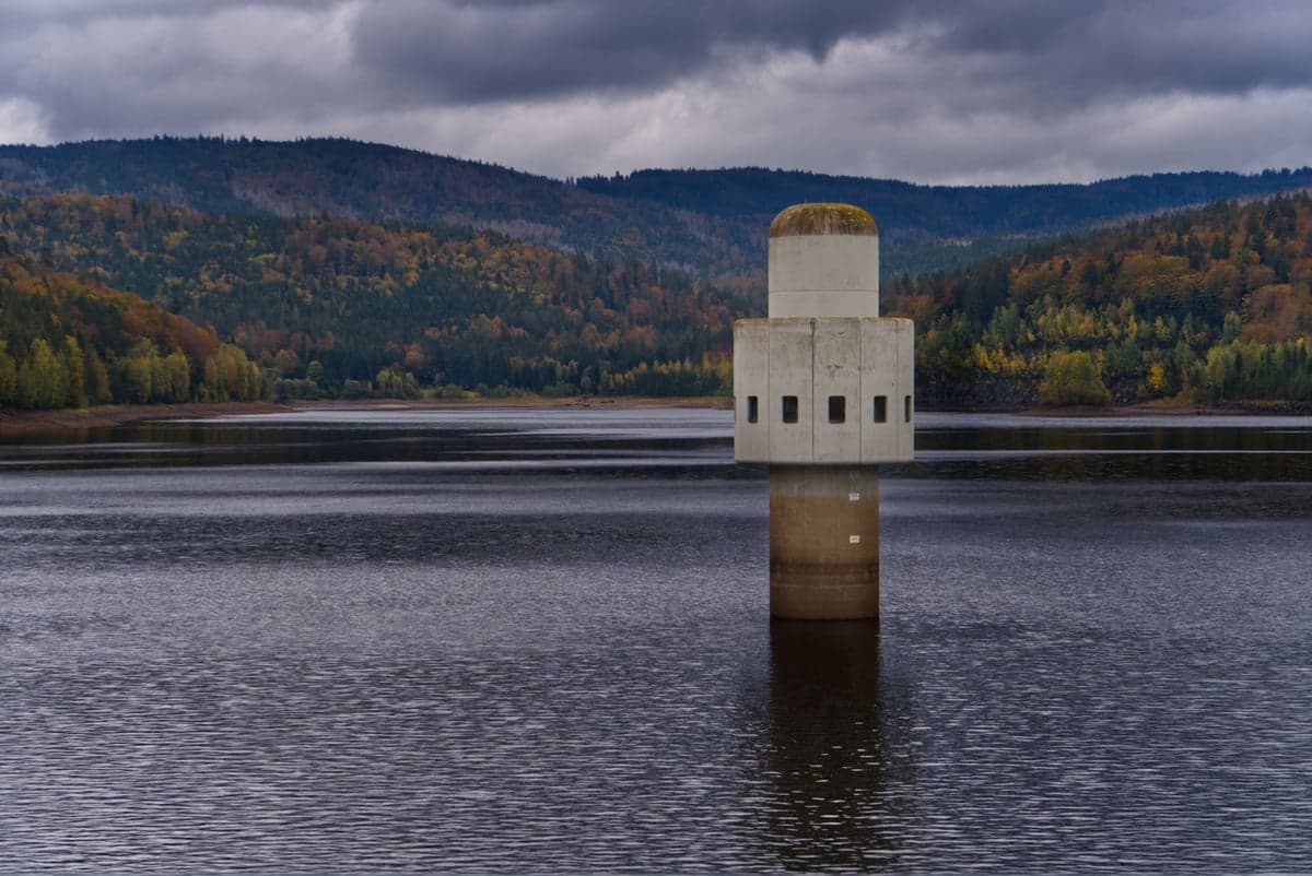 A reservoir intake tower surrounded by autumn forest. Bottom releases from NYC's Cannonsville and Pepacton reservoirs keep the Delaware's tailwaters cold enough for trout year-round.