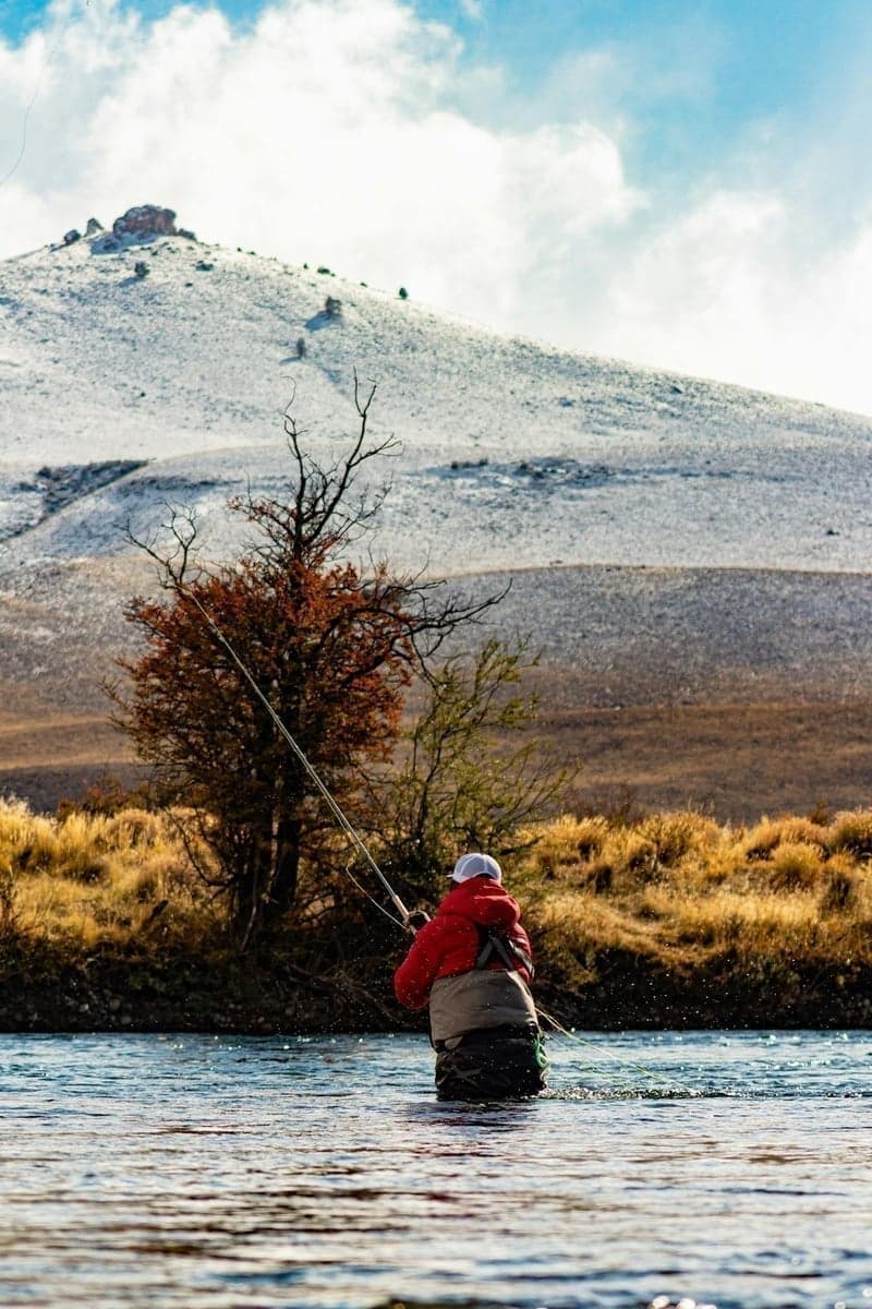 A fly fisherman wading a mountain river - this is what Colorado beginner fishing looks like