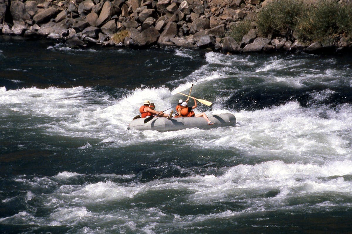 Whitewater rafting through a canyon, similar to the Bear Trap Canyon experience on the Madison