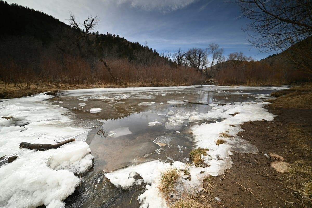 Late winter on an exposed high-country river. Shelf ice on the margins with open water in the middle is normal here through February.