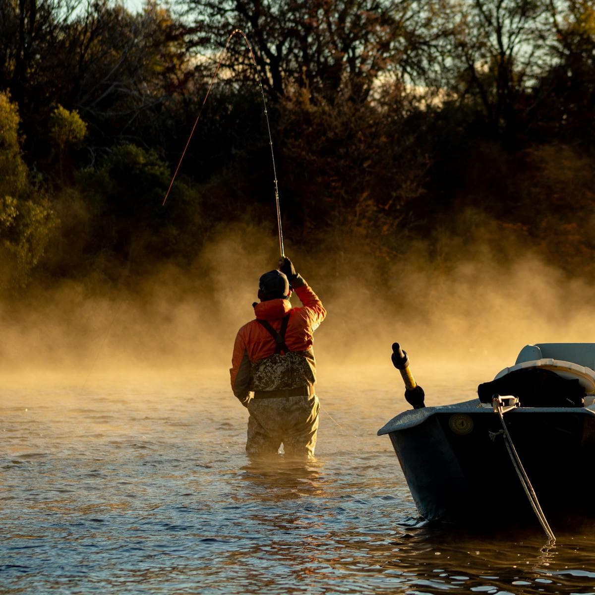 Fly angler casting at dawn on a misty Appalachian tailwater river in Tennessee