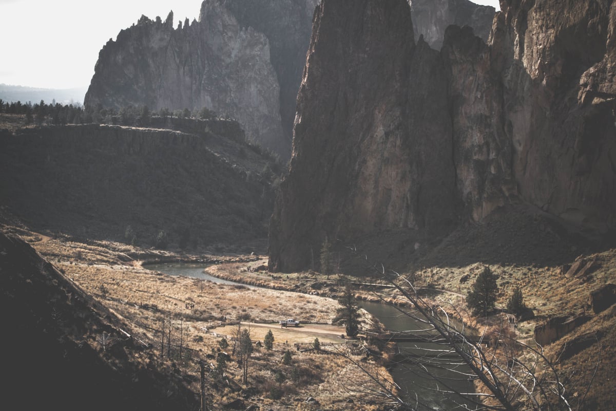The Deschutes River winding through a deep canyon with towering basalt cliffs and arid terrain